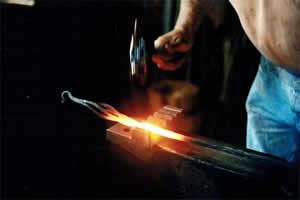 Blacksmithing: Jim Brimble pounds some metal in our blacksmithing shop